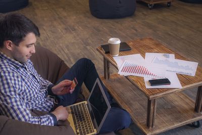 Man with a laptop and a credit card to pay the bill.