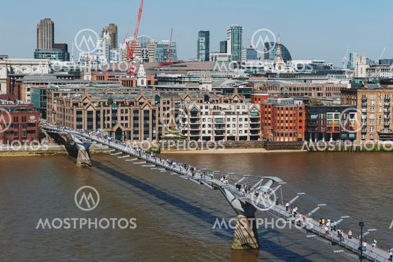 London, UK - April 2018: The London Millennium Bridge, a suspension footbridge for pedestrians crossing the River Thames linking Bankside with the City of London, with skyline of London and St Paul Cathedral seen in background