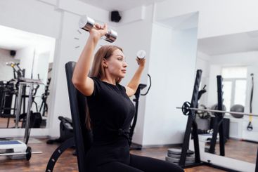 Athletic young blondy woman in black sportswear is doing...