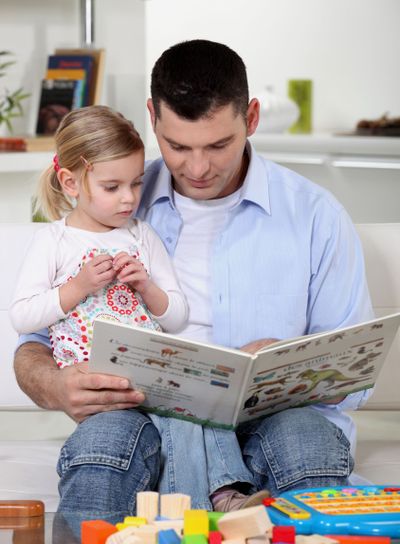 father reading a book to his little girl