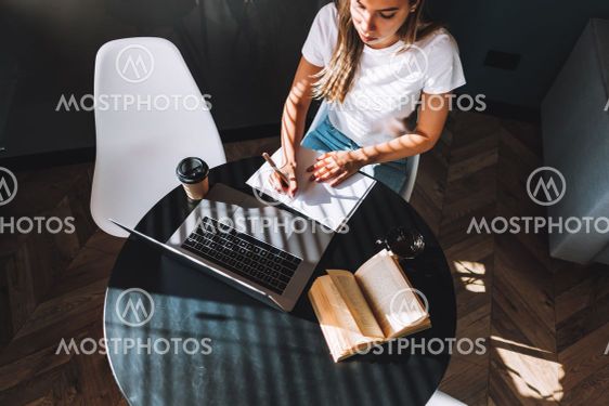 Focused caucasian young woman college student studying...