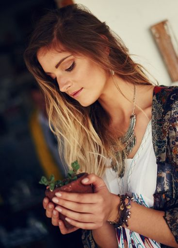 Woman, pot plant and spring in garden for growth,...