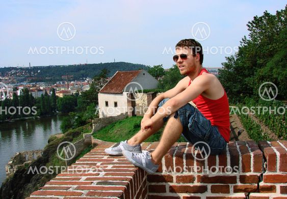 A guy sitting on a fence