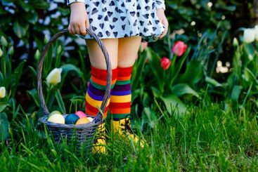 Close-up of legs of toddler girl with colorful stockings...