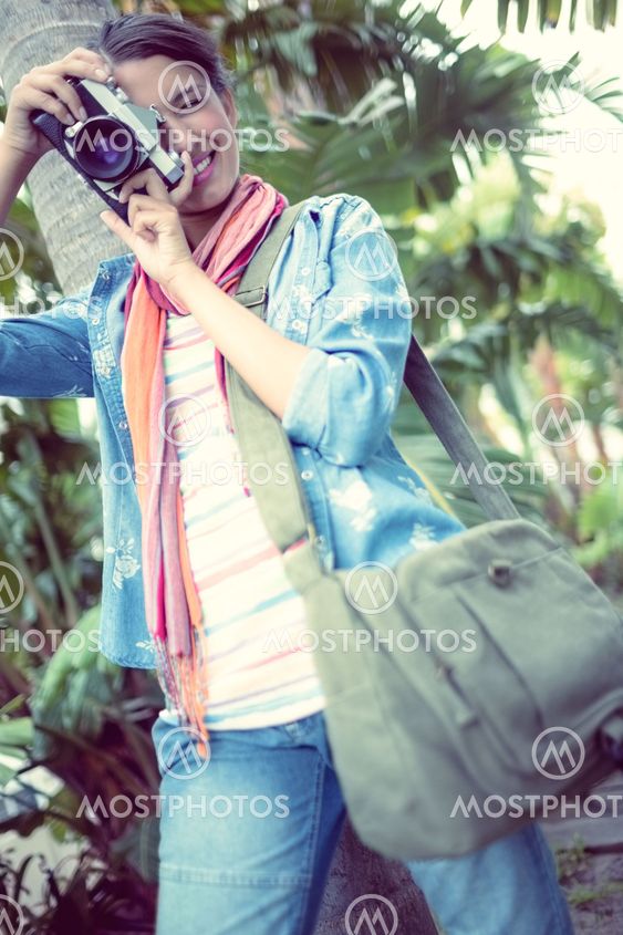 Happy photographer standing outside taking a photo