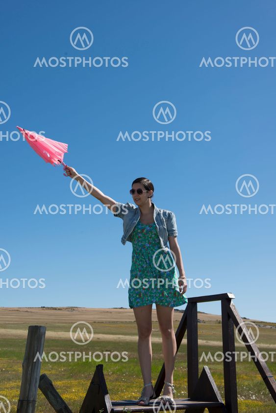Beautiful adult smelling flowers on sunny field enjoying herself