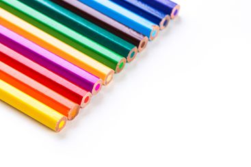 Colorful assortment of colored pencils arranged in a row...