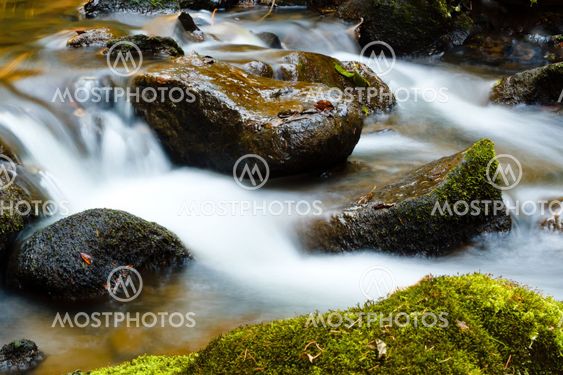 Falls on the small mountain river in a wood shooted in autumn