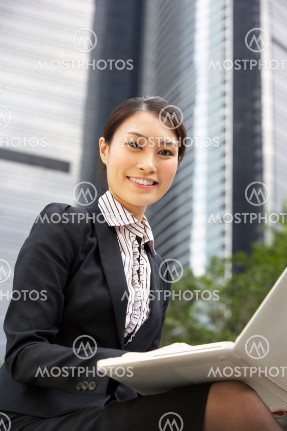 Chinese Businesswoman Working On Laptop Outside Office