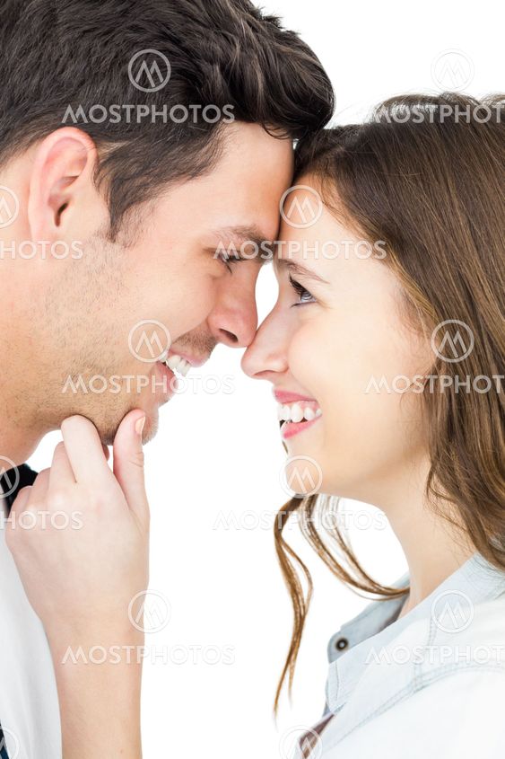 Couple standing head against head and holding chin