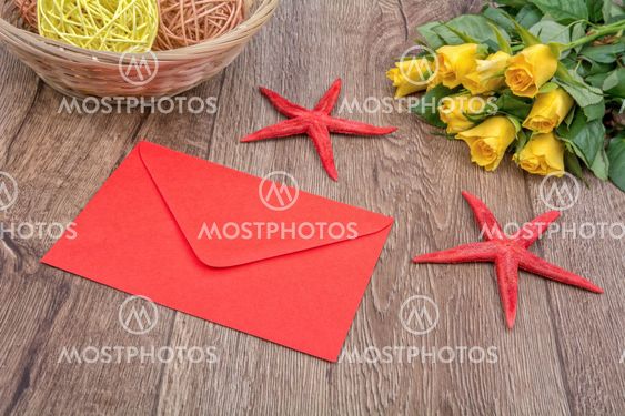 Envelope, starfishes and roses on a wooden background