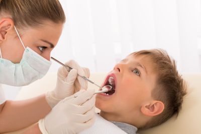 Dentist Examining Teeth Of Child Patient