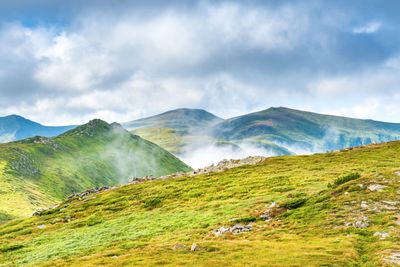 Panorama of green mountains with peaks
