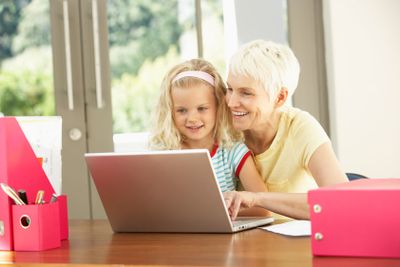 Granddaughter And Grandmother Using Laptop At Home