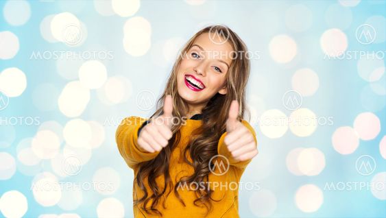 happy young woman or teen girl showing thumbs up