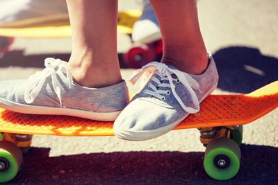 close up of feet riding skateboards on city street
