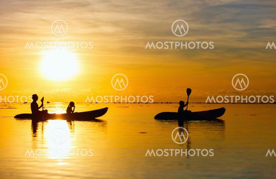 Family kayaking at sunset