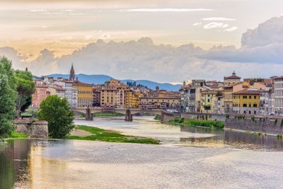 Daylight view to sunset above Arno river with reflections