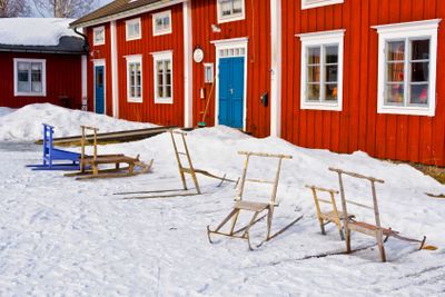 Swedish kick sledges in winter and a red house