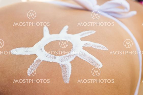 Woman With Sun Shaped Suntan Lotion On Back