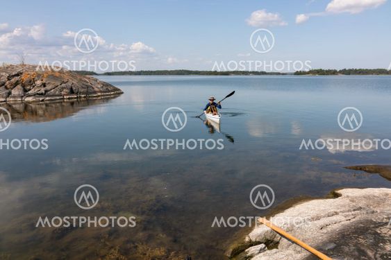 man paddlar kajak i skärgården