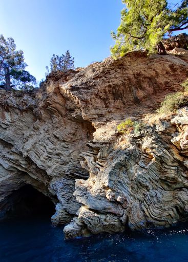 a large cave on the seashore is washed by water