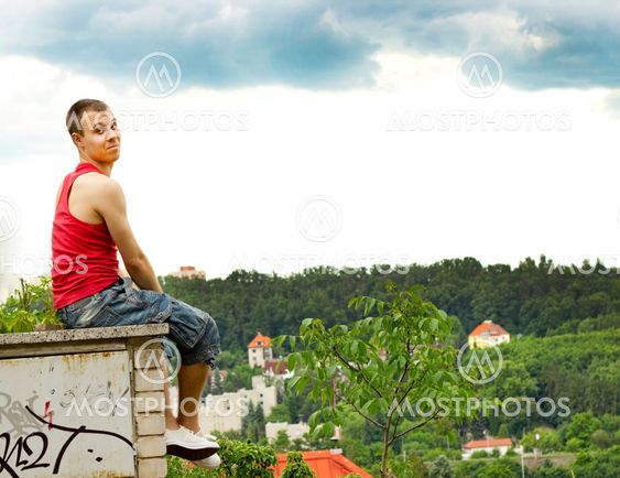 A guy sitting on a fence