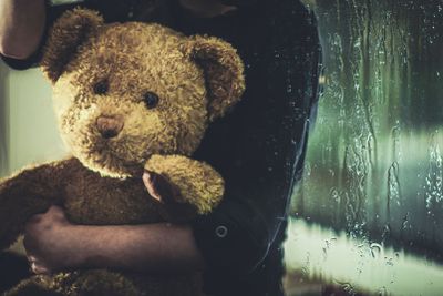 Child With Teddy Bear Sitting On Windowsill At Night. 
