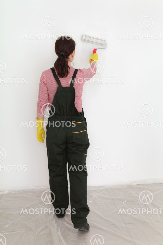 Young worker paint wall in a room to white