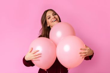 Playful Young Lady Cuddling Three Balloons And Sincerely...