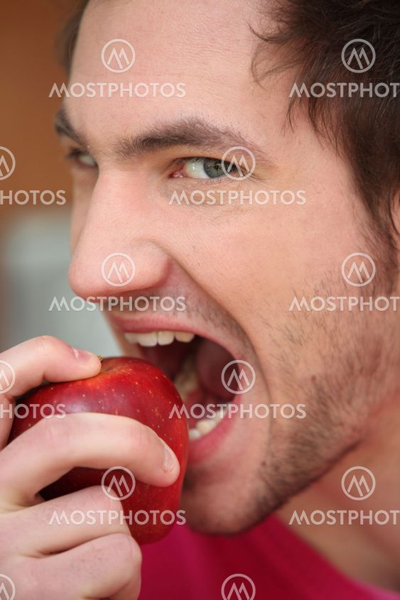Man biting into a red apple