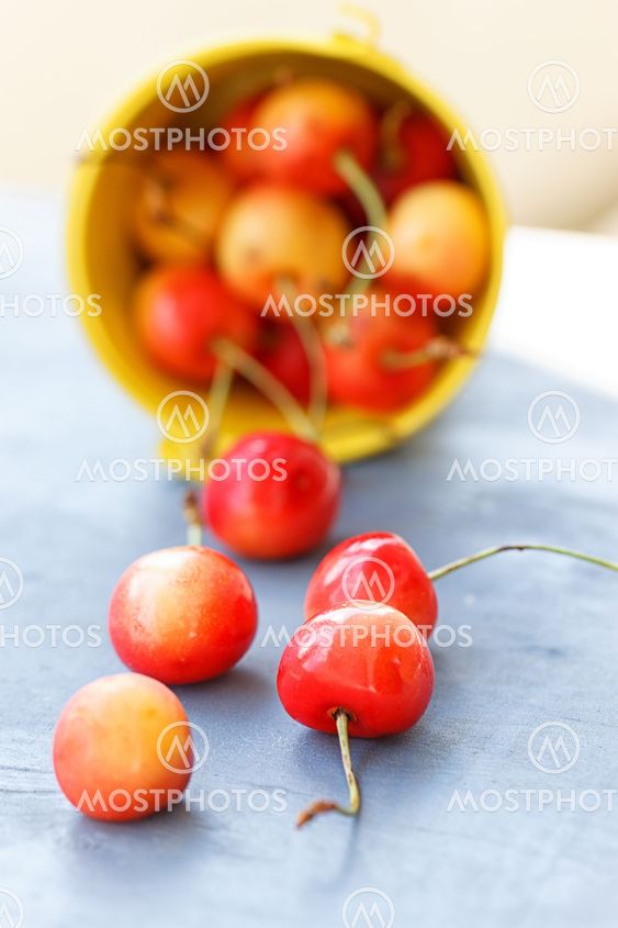 Cherries in a bucket on old wooden table