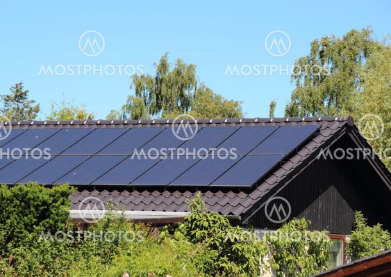 Solar collector on house roof with blue sky