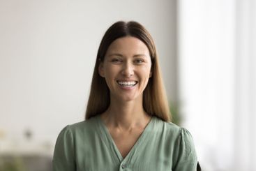 Headshot portrait of beautiful young woman smiles...