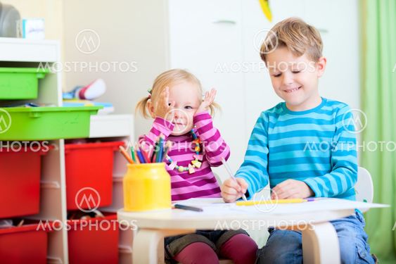 Kids sitting together at table drawing