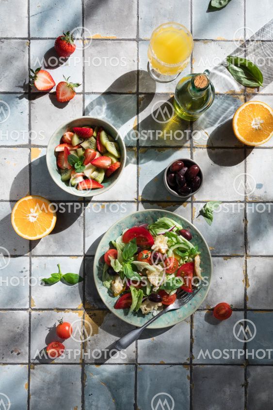 Mediterranean dishes at tiles table: vegetable and fruit...