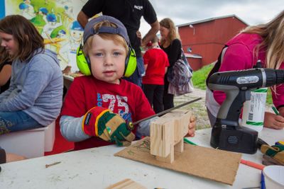 En pojke får prova på snickeri.