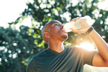 Fitness, black man and drinking water outdoor for...