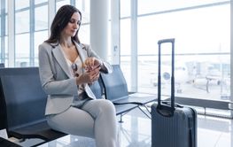 businesswoman at airport checking time as the flight is...