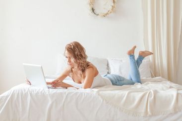 Serious young woman working with laptop at home