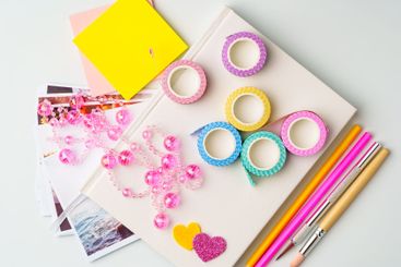 Crafting supplies on a table featuring colorful washi...