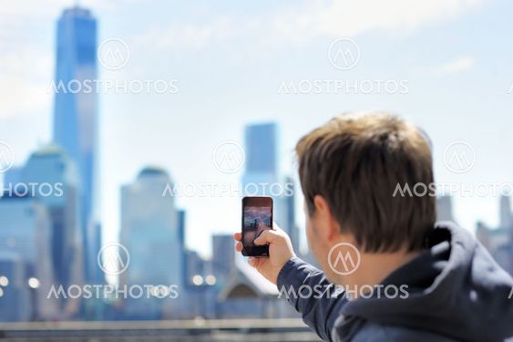 Tourist taking mobile photo of skyscrapers