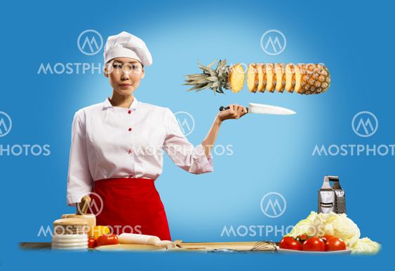 Asian female chef cuts pineapple