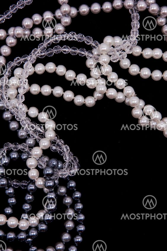 White and black pearls on the black silk