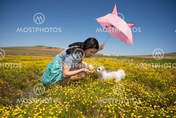 Beautiful adult smelling flowers on sunny field enjoying herself