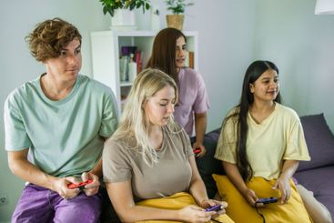 Friends playing video games together at home, leisure...