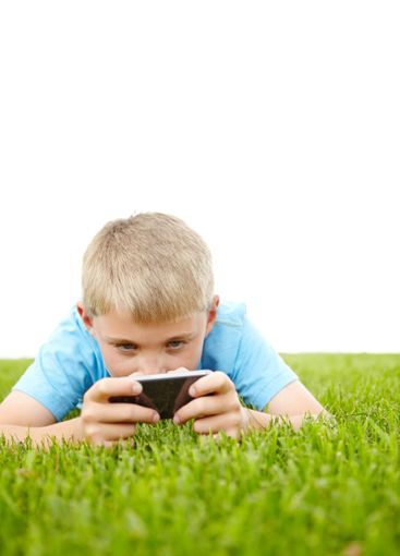 Little boy, grass field and playing with phone for video...
