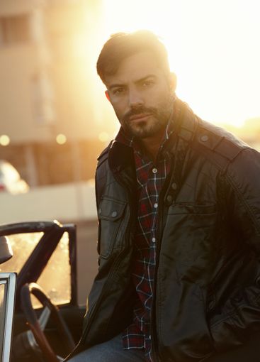 Portrait, relax or man by car in city for solo holiday,...