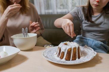 Mother and daughter decorating Easter cakes together.