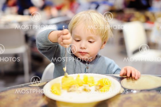 Toddler boy eating in cafe